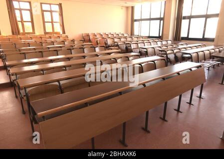 Shot of an empty high school classroom due to measures taken regarding global pandemic covid 19 Stock Photo