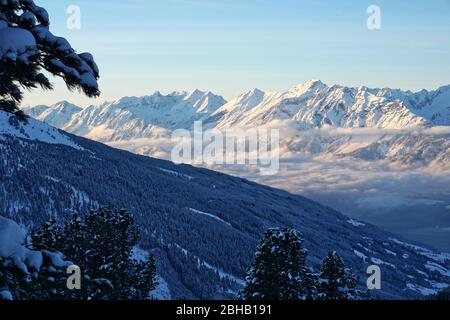 panoramic view of the misty Inntal valley and the snow covered Karwendel mountains in the soft winter evening light