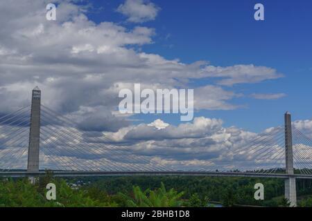 Bucksport, Maine: Clouds in a blue sky over the Penobscot Narrows Bridge. The bridge is a 2,120 ft. long cable-stayed bridge over the Penobscot River. Stock Photo