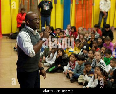 Austin Texas USA, October 30 2009: Third-grade students listen to children's author Derrick Barnes, author of 'Ruby and the Booker Boys' and other books, read at a ' Reading Rock Stars' appearance for the Texas Book Festival. The program pairs authors with schools to help children develop a love of reading books. ©Bob Daemmrich Stock Photo