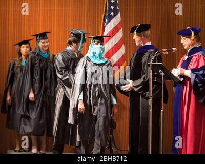 Austin, Texas USA, May 22, 2009: Graduation ceremony at the Lyndon Baines Johnson (LBJ) School of Public Affairs. Approximately 108 students received their Masters or PhD degrees in public policy studies through the school at the University of Texas at Austin. A female Muslim student wearing a niqab receives her diploma onstage. ©Bob Daemmrich Stock Photo