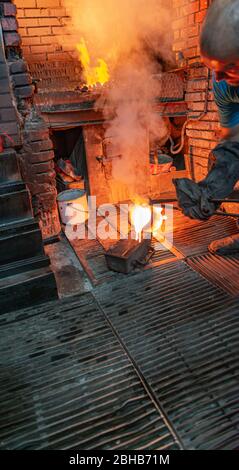 Pouring Molten Gold into a bar mold, inside of the smelter of the Round ...