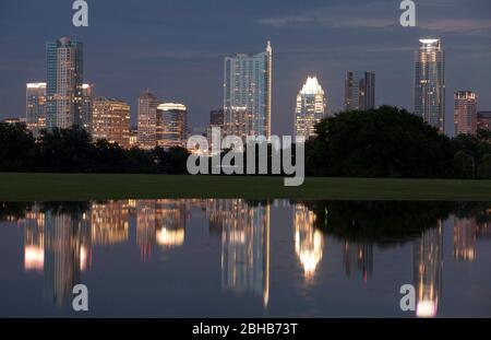 Austin Texas USA, June 2010. The Austin skyline is reflected in a large pool of rainwater standing in downtown's ZIlker Park after the Austin area receives several inches of rain and begins to feel the effects of Hurricane Alex. Alex is expected to make landfall Thursday in far south Texas. ©Bob Daemmrich Stock Photo