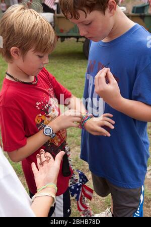 Austin, Texas USA, July 2010: Pre-teen boys trade Silly Bandz at park. ©Bob Daemmrich Stock Photo