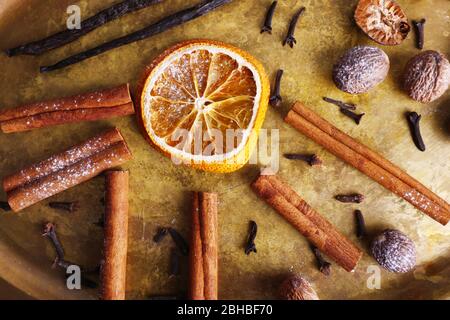 Cinnamon and vanilla sticks, dried orange, nutmeg and cloves on metal tray background Stock Photo