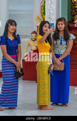 Young Burmese women taking a selfie at Shwedagon pagoda in Yangon Stock Photo