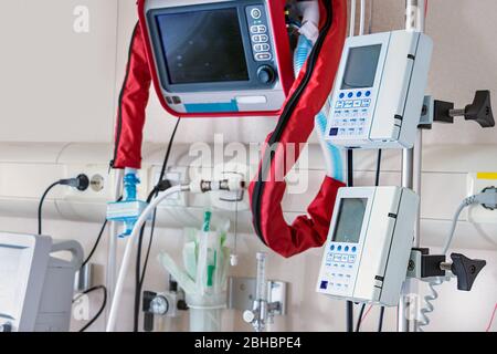 Ventilators and vital sign monitors next to Intense Care Unit bed Stock Photo