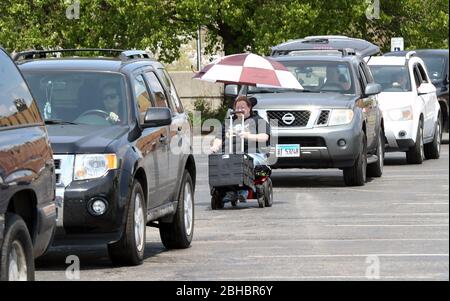 Alton, United States. 24th Apr, 2020. A recipient, waits in line for food in their motorized wheel chair as they approach the loading area in Alton, Illinois on Friday, April 24, 2020. Over 1700 cars lined up to receive food, distributed by the Urban League of Greater St. Louis. Photo by Bill Greenblatt/UPI Credit: UPI/Alamy Live News Stock Photo