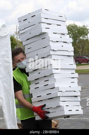 Alton, United States. 24th Apr, 2020. A volunteer carries boxes that will hold food, during a free food give-a-way, in Alton, Illinois on Friday, April 24, 2020. Over 1700 cars lined up to receive food, distributed by the Urban League of Greater St. Louis. Photo by Bill Greenblatt/UPI Credit: UPI/Alamy Live News Stock Photo