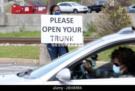 Alton, United States. 24th Apr, 2020. A volunteer holds a sign asking for those waiting in line for free food, to open their trunks in Alton, Illinois on Friday, April 24, 2020. Over 1700 cars lined up to receive food, distributed by the Urban League of Greater St. Louis. Photo by Bill Greenblatt/UPI Credit: UPI/Alamy Live News Stock Photo