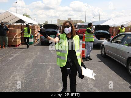 Alton, United States. 24th Apr, 2020. A volunteer guides a car into the loading area for free food in Alton, Illinois on Friday, April 24, 2020. Over 1700 cars lined up to receive food, distributed by the Urban League of Greater St. Louis. Photo by Bill Greenblatt/UPI Credit: UPI/Alamy Live News Stock Photo