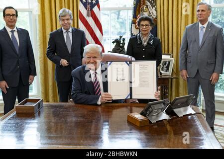 Washington, United States Of America. 24th Apr, 2020. President Donald J. Trump displays his signature after signing H.R. 266, the 'Paycheck Protection Program and Health Care Enhancement Act' Friday, April 24, 2020, in the Oval Office of the White House People: President Donald Trump Credit: Storms Media Group/Alamy Live News Stock Photo