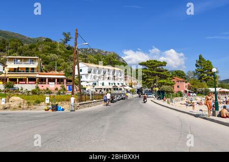 The beachfront Mediterranean village of Palaiokastritsa on the island of Corfu, Greece, in the Ionian Sea, on a summer day filled with tourists. Stock Photo