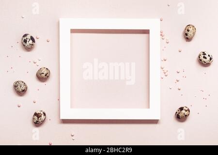 White Frame and quail eggs over pink pastel background. Happy easter minimal concept. Stock Photo