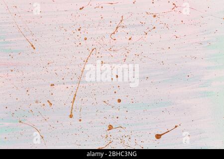 Golden splashes and drops on pink pastel background. Hand painted background or texture for your design. Stock Photo