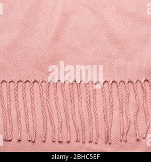 Cozy soft fabric background with copy space. Pink plaid with tassels. Stock Photo