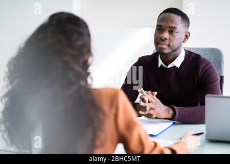 Two Businesspeople Talking With Each Other At Office Stock Photo