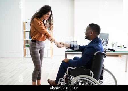 Two Happy Businesspeople In Office Shaking Hands Stock Photo