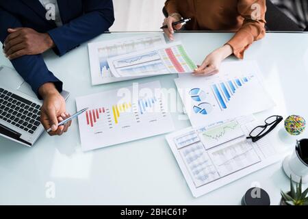 Cropped Image Of Businesswoman Writing On Graph At Desk In Office Stock Photo