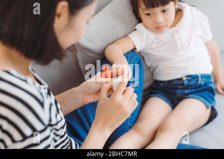 Little daughter with mother making pedicure at home Stock Photo