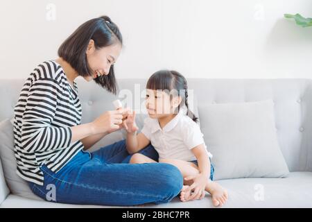 Mother and daughter paint their nails and have fun Stock Photo