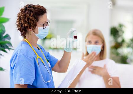 Doctor examining sick patient in face mask. Ill woman in health clinic for test and screening. Home treatment of virus. Coronavirus pandemic. Covid-19 Stock Photo