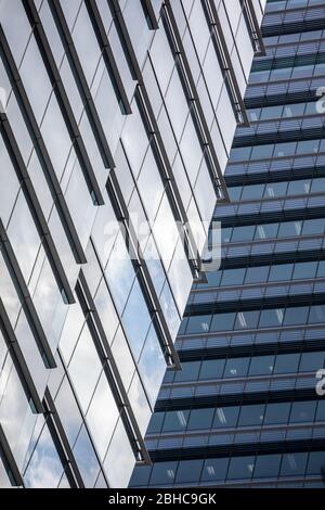 Skyscraper wall abstract background with repeated rectangular cells, mirrored glass wall. Metal gray color with repetitive texture. Stock Photo