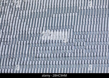 Skyscraper wall abstract background with repeated rectangular cells. Metal gray color with repetitive texture. Stock Photo