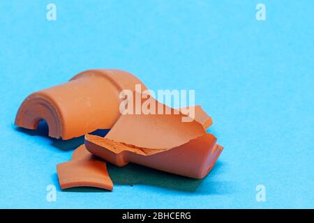 a broken flower pot on blue background Stock Photo