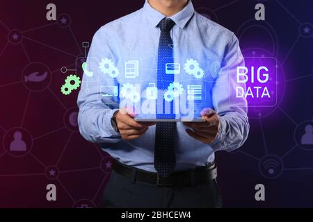 Businessman with tablet computer and hologram projection of data storage on dark background Stock Photo