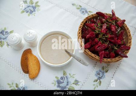 A bowl of white ceramic salt and pepper. Umac soup. Eggs beaten with salt water are sprinkled on the flour and flour is rubbed . Red Pepper in Stock Photo