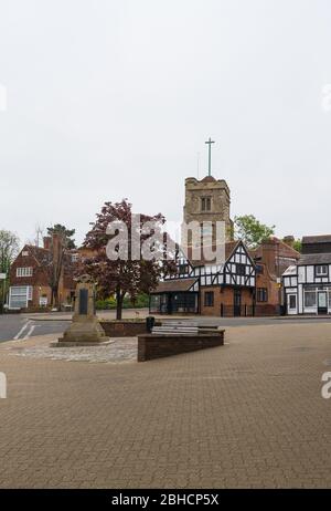 St. John the Baptist Church as seen from the High Street, Pinner, Middlesex, England, UK. First and second world wars memorial stands in foreground. Stock Photo