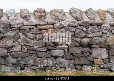 Traditionally laid random stone field wall with cemented stone top cropped in for no context Stock Photo