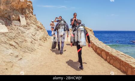 Egypt, Sharm El Sheikh - June 10, 2019: divers with snorkeling equipment go into the sea through the sky with clouds in Egypt Dahab. A blue hole in th Stock Photo