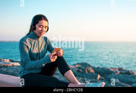 Asian girl enjoying music by the seaside Stock Photo