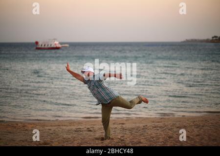 Portrait of a running caucasian man in a hurry on a sunset beach Stock Photo