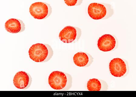 ripe, fresh, natural red cut strawberries pattern, a healthy spring and summer fruit, on white background Stock Photo