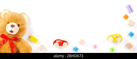 Baby kids toys banner background. Teddy bear, wooden cars, colorful bricks, blocks on white background. Top view Stock Photo