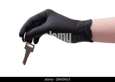 Hand in black leather glove with key isolated on white background Stock Photo