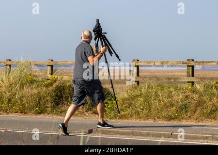 Birdwatching, or birding, birders, wildlife observation binoculars, scopes, optics, tripods at Southport, Merseyside, UK. 25th Apr 2020. In the resort as local residents take light exercise on the Ribble Estuary RSPB reserve coastal path.  A local survey suggested up to 720 people had been counted on the beach recently during the course of one day.  Credit: MediaWorldImages/Ģ����ýLive News. Stock Photo