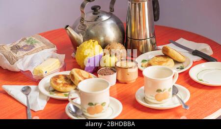 A breakfast table set for two with no people and no chairs and no tea in teacups Stock Photo