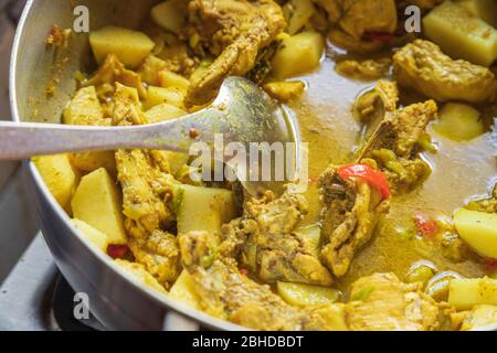 stewed curry chicken and Irish potatoes in sauce with red peppers Indian home food delightful Stock Photo