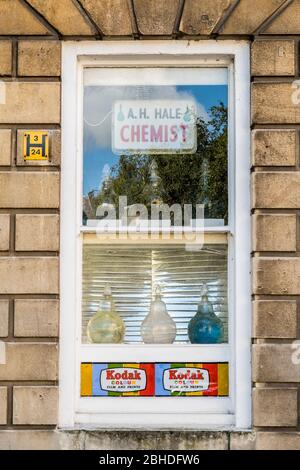 Traditional Chemists shop window with advert for Kodak colour film and prints. Stock Photo