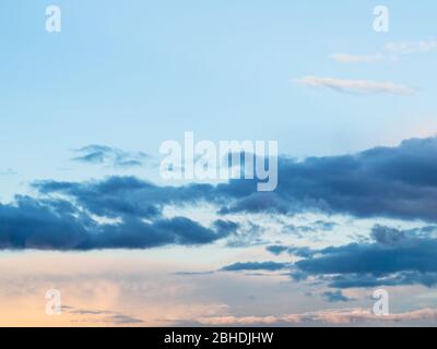 dark cumuli clouds in blue sky at spring sunset Stock Photo