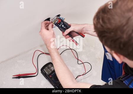 Hands man make connection terminal wire, hold crimping pliers. Design background. Professional materials. Electric work. Male hobby Stock Photo