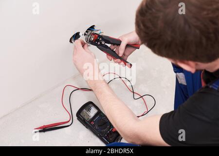 Hands man make connection terminal wire, hold crimping pliers. Design background. Professional materials. Electric work. Male hobby Stock Photo