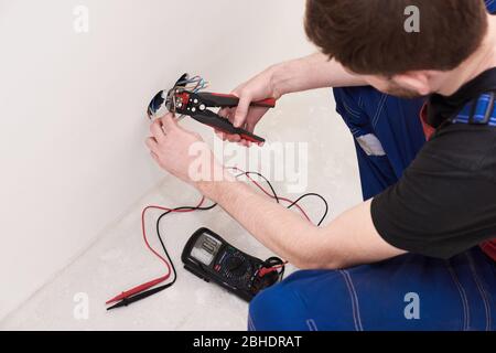 crimping pliers on the man hands. installation, repairs in the new flat Stock Photo
