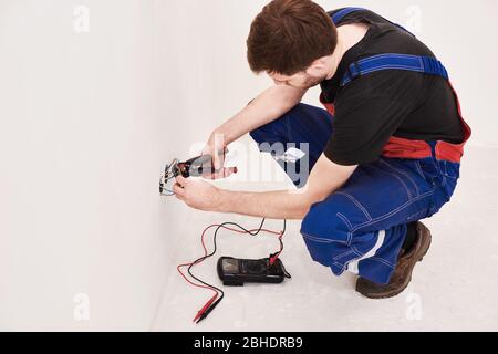 crimping pliers on the man hands. installation, repairs in the new flat Stock Photo