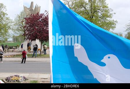 Torgau, Germany. 25th Apr, 2020. A flag with a dove of peace is waving at the Monument of Encounter. On the occasion of the 75th anniversary of the meeting of American and Soviet soldiers on April 25, 1945 - the so-called Elbe Day - a commemoration ceremony was held, which took place in a small circle because of the corona pandemic and was transmitted online. Credit: Sebastian Willnow/dpa-Zentralbild/dpa/Alamy Live News Stock Photo