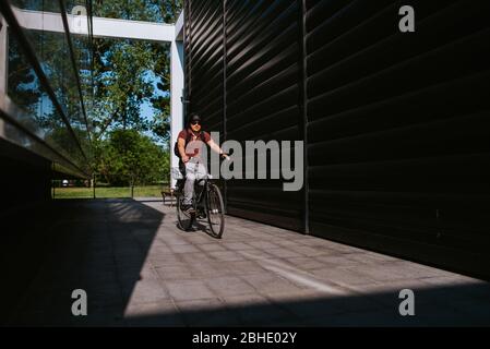 Handsome young caucasian man riding bicycle in the city Stock Photo